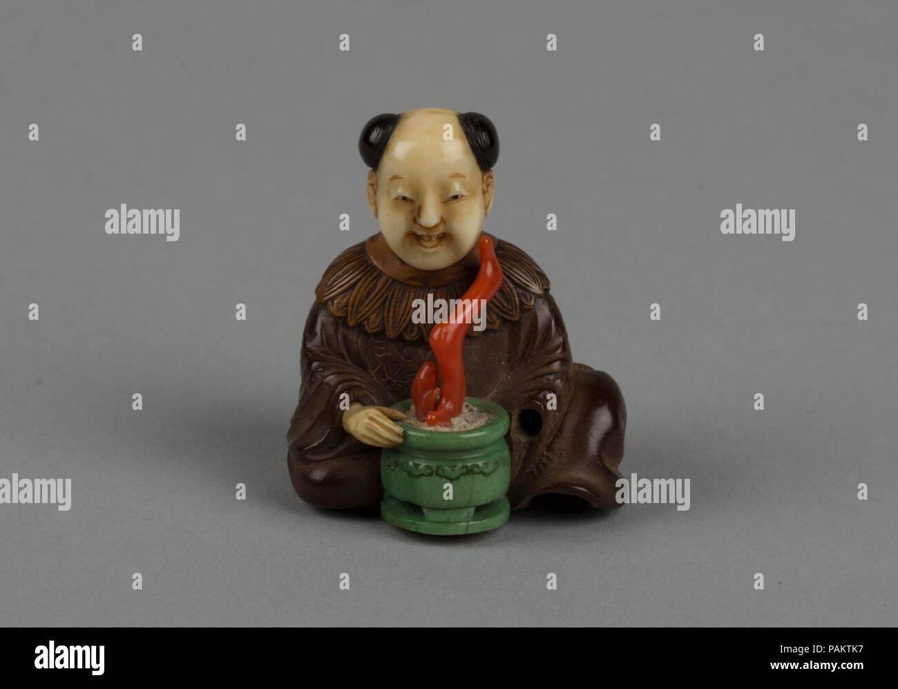 Netsuke di uomo seduto con un vaso di fiori. Cultura: il Giappone. Dimensioni: H. 1 1/4 in. (3.2 cm); W. 1 1/8 in. (2,9 cm0; D. 1 1/8 in. (2.9 cm). Data: del XIX secolo. Museo: Metropolitan Museum of Art di New York, Stati Uniti d'America. Foto Stock