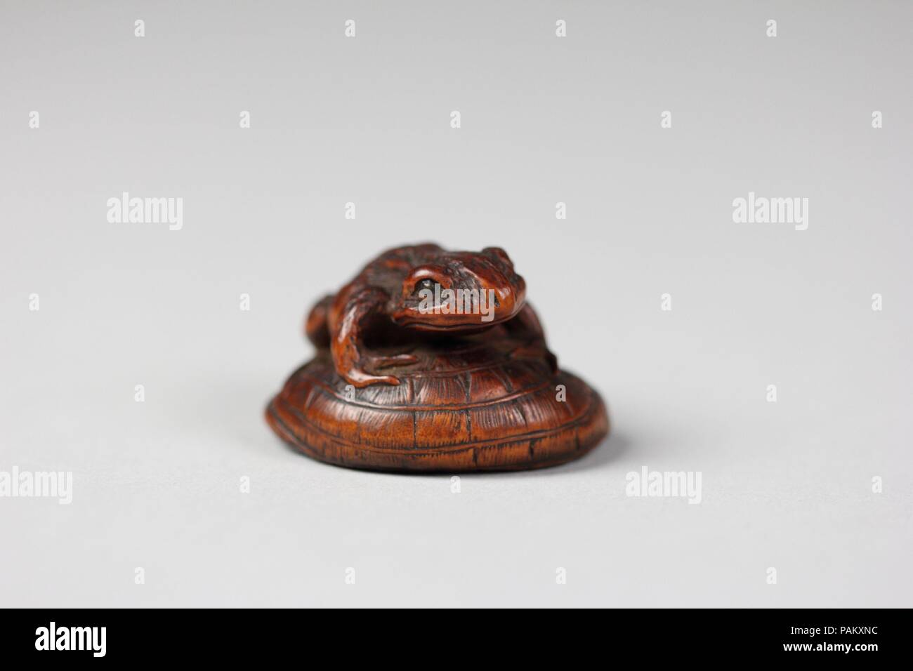 Netsuke di rana su un cappello di paglia. Cultura: il Giappone. Dimensioni: H. 1. (2,5 cm); W. 1 3/8 in. (3,5 cm); D. 1 1/2 in. (3.8 cm). Data: XVIII secolo. Museo: Metropolitan Museum of Art di New York, Stati Uniti d'America. Foto Stock