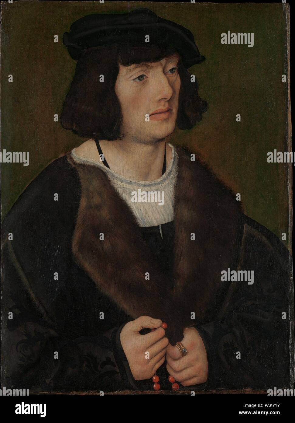 Ritratto di un uomo con un rosario. Artista: Lucas Cranach il Vecchio (tedesco, Kronach 1472-1553 Weimar). Dimensioni: 18 3/4 x 13 7/8 in. (47,6 x 35.2cm). Data: ca. 1508. Questo dipinto e un <i>Ritratto di una donna in preghiera</i> (Kunsthaus di Zurigo) formata inizialmente le ali di un trittico devozionale. Il giovane, ben vestito sitter sembra apparentemente trafitta da una ormai perduta immagine centrale--forse della Vergine e il Bambino--per la quale egli offre una preghiera silenziosa come egli mette in pausa su un cordone del rosario ha tenuto nelle sue mani. L'uomo di anello, con stemma di famiglia olandese di sei van Hillegom e Foto Stock