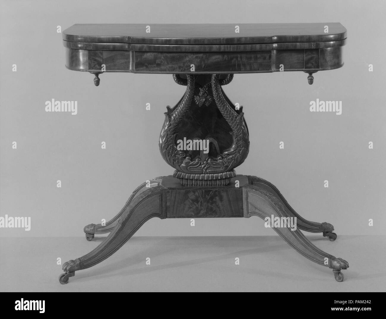 Tabella della scheda. Cultura: American. Dimensioni: 28 3/4 x 36 3/8 x 35 7/8 in. (73 x 92,4 x 91,1 cm). Maker: Probabilmente Henry Connelly (1770-1826). Data: 1815-20. L attribuzione di questa scheda tabella è basata sulla sua somiglianza con una coppia di tavole Henry Connelly realizzato per la prominente Philadelphia banchiere e filantropo Stephen Girard nel 1817. Tutti sono distinti dai loro eleganti proporzioni, scintillante superfici di mogano e raffinati intagli. I delfini--popolare francese ispirata a motivi in sia a New York e da Filadelfia mobili durante i primi decenni del XIX secolo -- qui la grazia di una a forma di lira Foto Stock