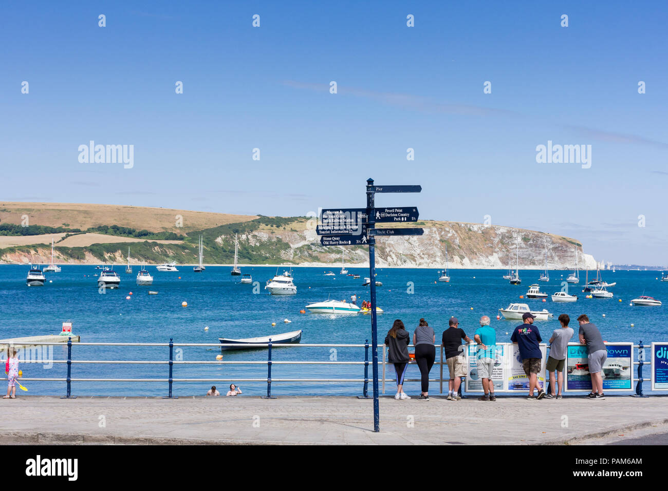 Persone a Swanage Promenade affacciata sul mare su un calde estati soleggiate giorno durante la canicola del 2018, Dorset, Regno Unito Foto Stock