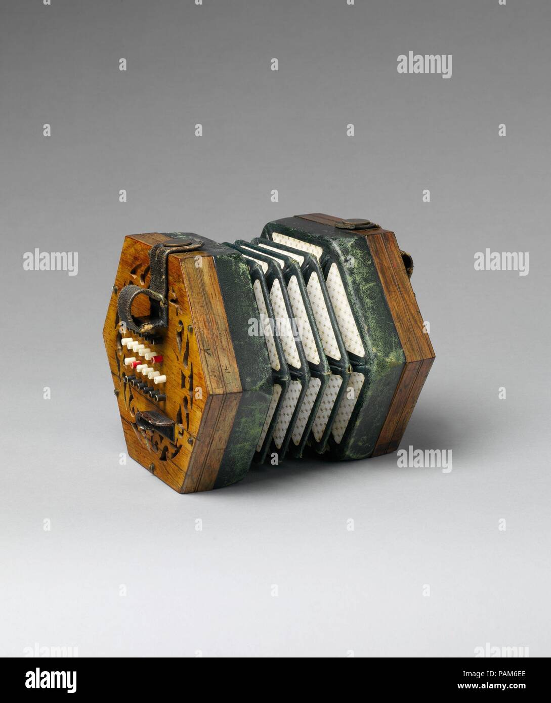 Concertina. Cultura: British. Dimensioni: W. attraverso le estremità 15.9 cm (6 1/4 poll.) da punto a punto: 18,3 cm (7 1/4 in.). D. (chiuso) 10,8 cm (4 in.). Autore: Charles Wheatstone (1802-1875). Data: ca. 1862. Uno studente modello con i tasti colorati per facilitare l'orientamento delle dita: i pulsanti bianchi sono per i toni diatonica, rosso è C, i tasti neri sono le alterazioni. Museo: Metropolitan Museum of Art di New York, Stati Uniti d'America. Foto Stock