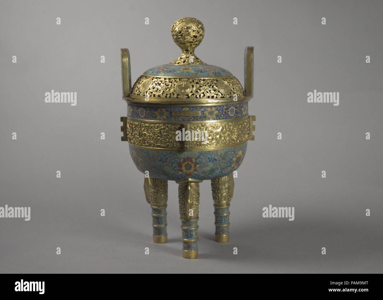 Uno di una coppia di bruciatori di incenso. Cultura: la Cina. Dimensioni: H. 15 1/2 in. (39,4 cm); W. 8 3/4 in. (22,2 cm). Navi da della Cina antica età del Bronzo culture, come Shang (ca. 1600-ca. 1050 a.C.) e Zhou (ca. 1046-256 A.C.) dinastie, spesso servito come prototipi per la successiva lamiera, particolarmente quelli con rituali o funzioni cerimoniali. La forma di questo bruciatore di incenso è basato su un treppiede arcaico nave noto come un ding, che è stato usato per trattenere o che servono cibo e le altre offerte. I cartigli floreali in background sono impreziosite da sollevato gilt-banda di bronzo al centro, w Foto Stock