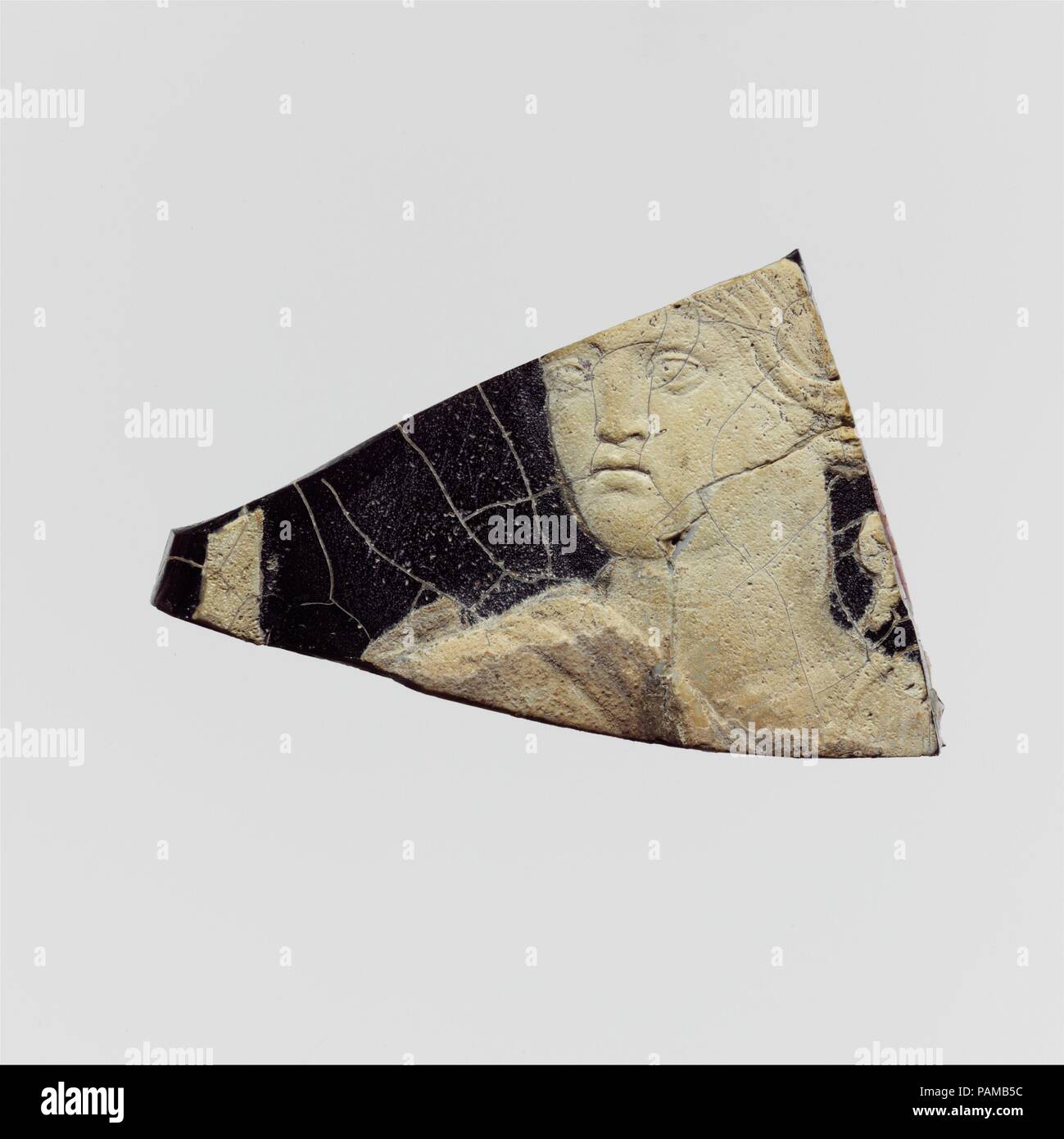 Cameo di vetro frammento di placca. Cultura: Romano. Dimensioni: complessivo: 1/4 x 2 3/8 in. (0,7 x 6 cm). Data: I secolo D.C.. Traslucidi viola scuro con bianco opaco overlay. Parte inferiore piana; leggermente superficie ondulata con decorazione in rilievo; piccola sezione di sinistra con bordo arrotondato il labbro superiore. In rilievo in bianco, testa di figura ruotata a sinistra, con lunghi capelli ondulati occultare buon orecchio sinistro, indossa una tunica in ampie fasce sulle spalle; dietro il corretto spalla sinistra parte di oggetto non identificato; a sinistra della figura, parte di una lunga e personale. Rotta su tre lati con bordi a spiovente; molti la deformazione interna Foto Stock