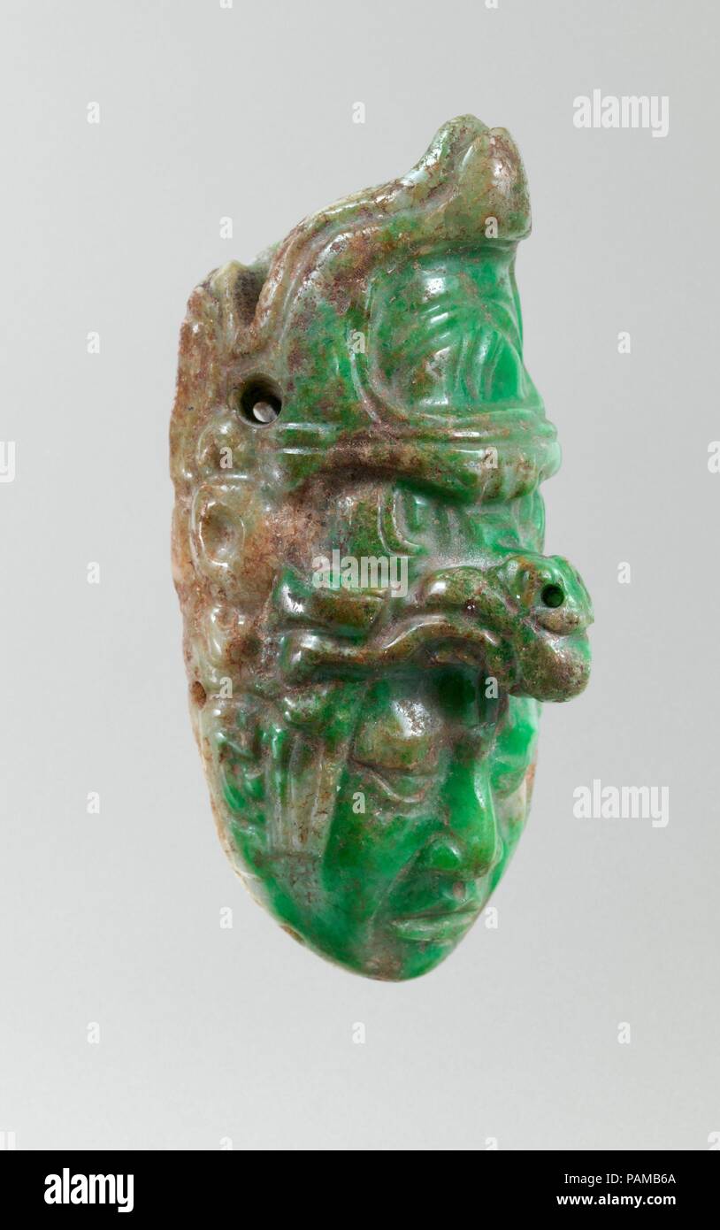 Telecomando. Cultura: Maya. Dimensioni: H. 3 × larg. 1 1/2 × D. 1 1/2 in. (7,6 × 3,8 × 3,8 cm). Data: A.D. 600-700. Questo luminoso verde giada ciondolo raffigura un righello di Maya che indossa il copricapo di un essere supernatural. Este colgante de jade verde rappresentanouna un gobernante onu maya con el tocado de onu ser sobrenatural. <b>Ulteriori informazioni</b> Questo luminoso verde giada ciondolo raffigura un righello di Maya che indossa il copricapo di un essere supernatural. La metà inferiore del altamente in pietra levigata è un percorso naturalistico volto di un Maya signore il cui labbra sono leggermente scostati, come se in procinto di parlare. La faccia sembra emergere Foto Stock