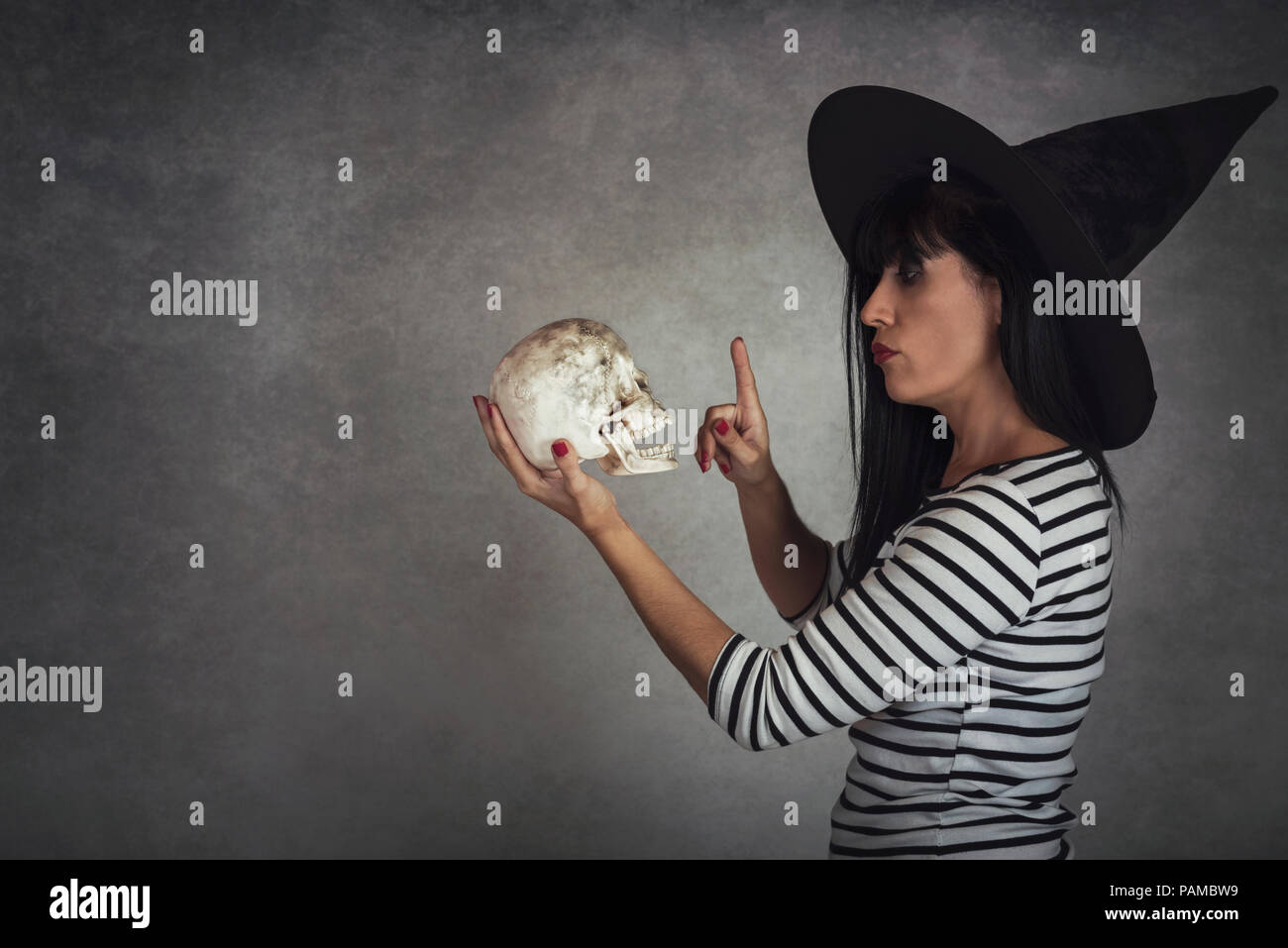 Giovane donna tenendo un cranio in halloween Foto Stock