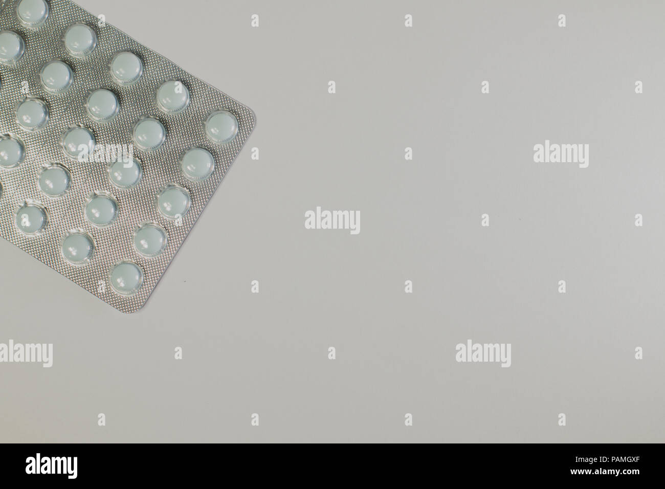 Medicinali su sfondo grigio di un colore differente Foto Stock