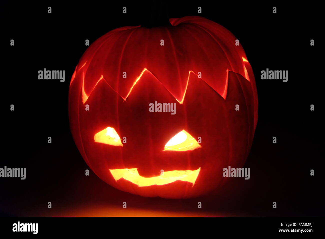 Illuminatd testa di zucca con brutto viso a Helloween Foto Stock