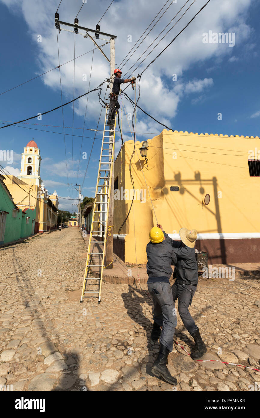 I lavoratori di utilità Esecuzione di cavi di alimentazione nel sito Patrimonio Mondiale dell'UNESCO città di Trinidad, Cuba. Foto Stock