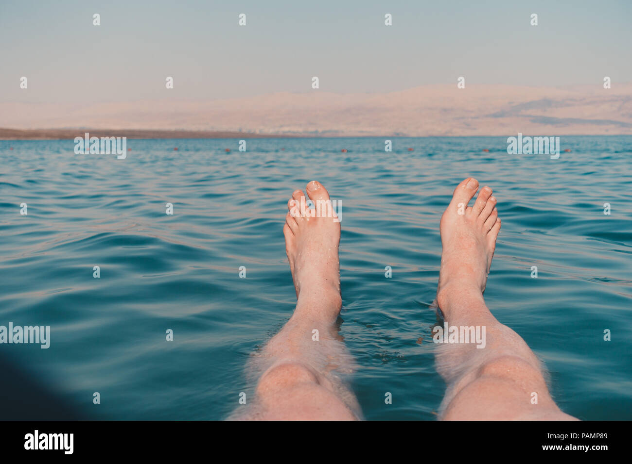 Piedi di bob e galleggiare nel Mar Morto, Israele, che è così salato è impossibile per un corpo umano per lavello Foto Stock