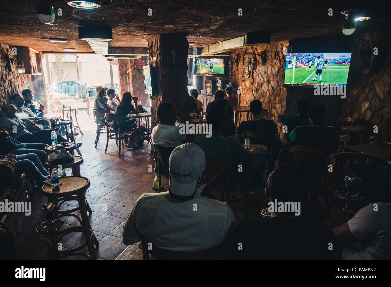 Un gruppo di uomini giordani fumare narghilè e guardare Argentina giocare in Francia per la Coppa del Mondo FIFA 2018 in un bar di Wadi Musa, Giordania Foto Stock