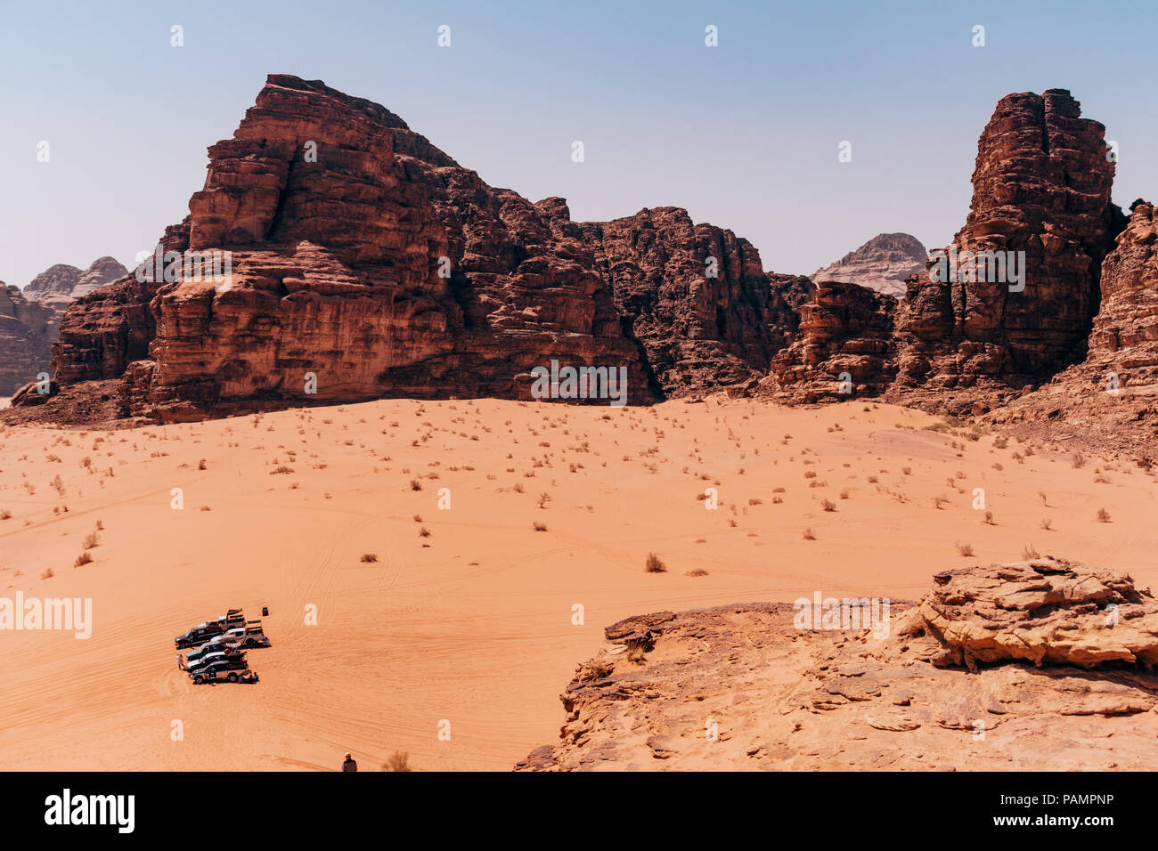 I suv attendere tra la sabbia arancione e rocce per turisti vicino al 'Sanche pilastri" nel Wadi Rum desert, Giordania Foto Stock