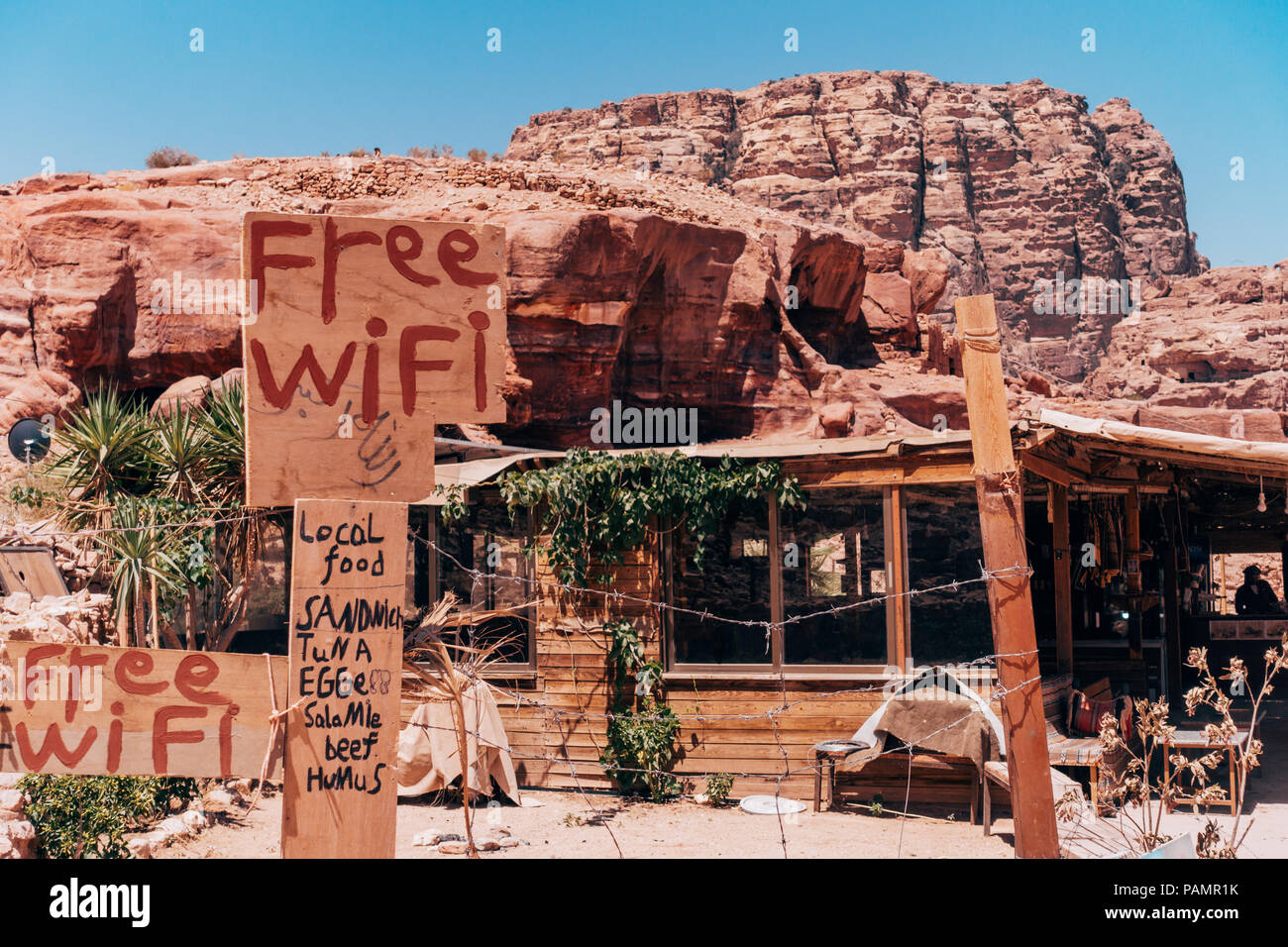 Una capanna in legno ristorante della città perduta di Petra, Giordania, cerca di attirare i clienti promuovendo i loro menu di cibo e internet wifi Foto Stock