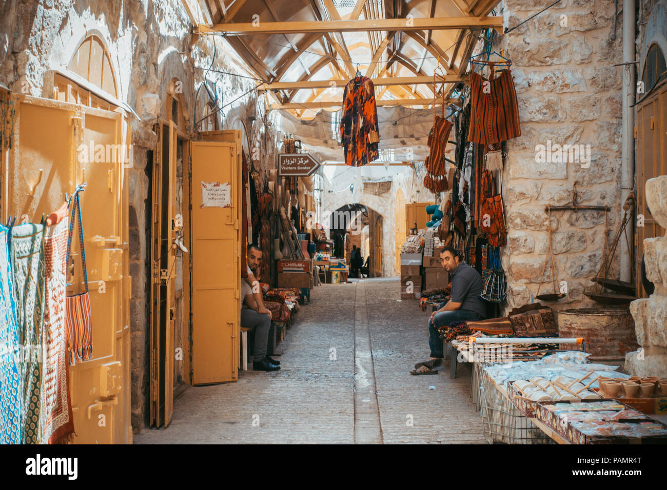 I negozianti sedersi in un vuoto di mercato di Hebron, Israele. Il turismo è stato in netto declino qui Foto Stock