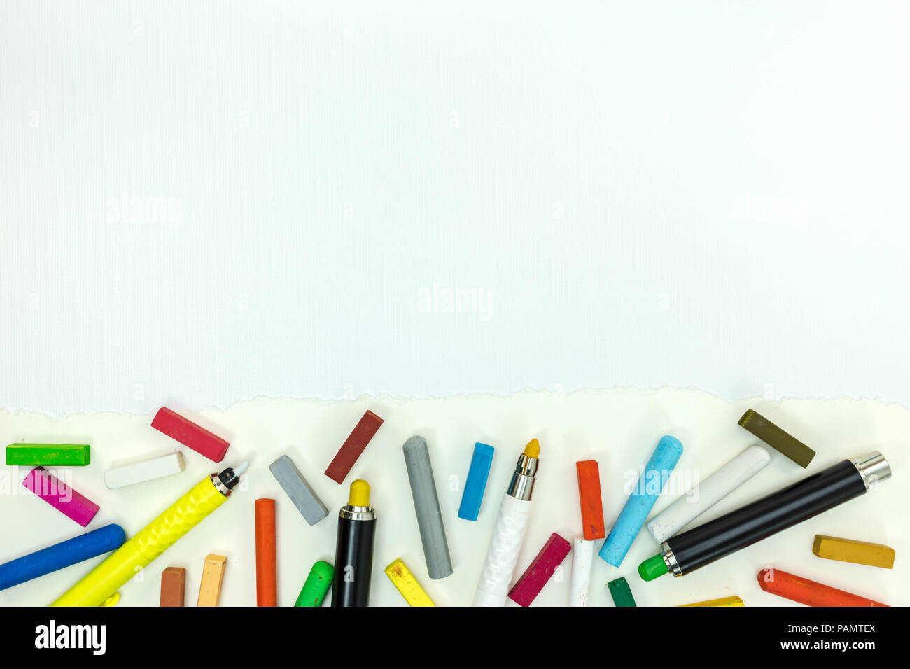 Marcatori e matite colorate sul foglio di carta. Gli strumenti di disegno su sfondo bianco con spazio di copia Foto Stock
