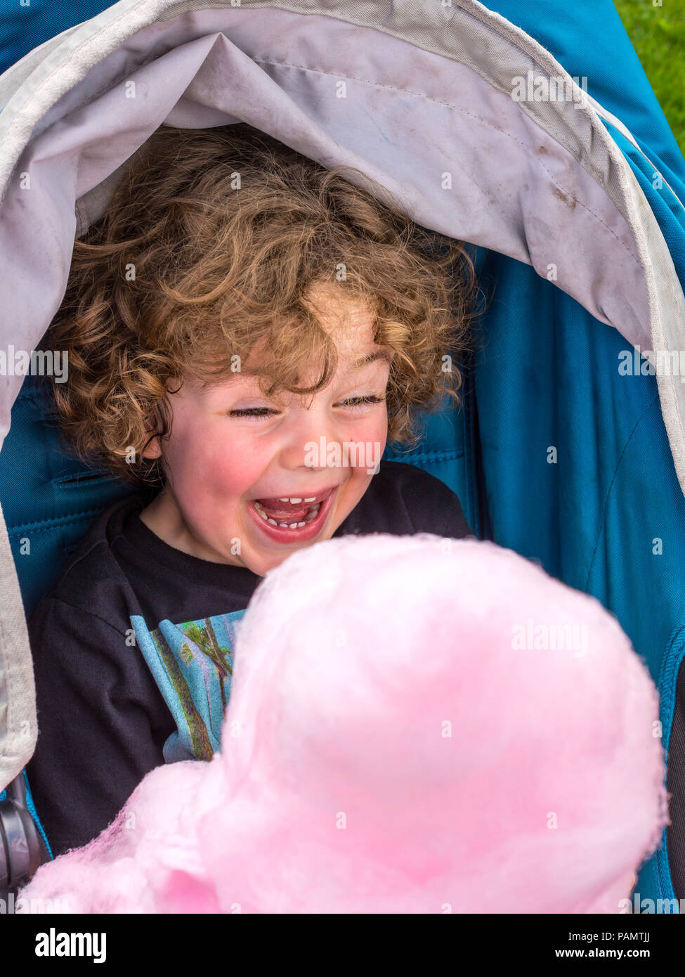Un giovane bambino godendo la sfera di rosa Candy Floss - Francia. Foto Stock