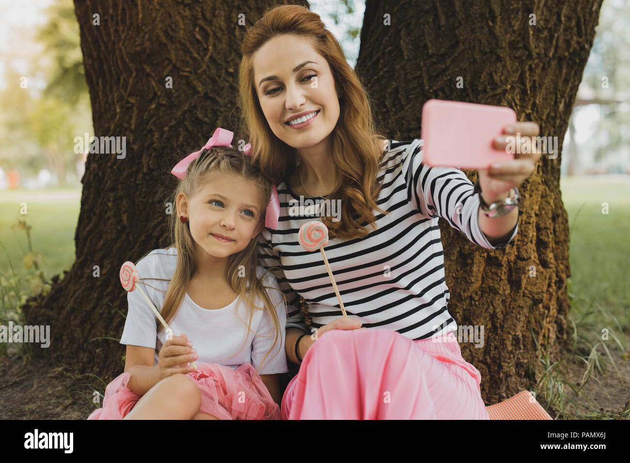 Moderno e amorevole madre rendendo selfie con graziosi figlia Foto Stock