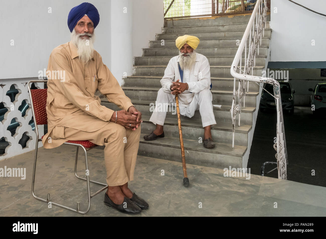 Due uomini nei turbanti sikhiani sono seduti e riposati in un passaggio sotterraneo che conduce al Tempio d'Oro a Delhi, Tempio Sikh, India giugno 2018 Foto Stock