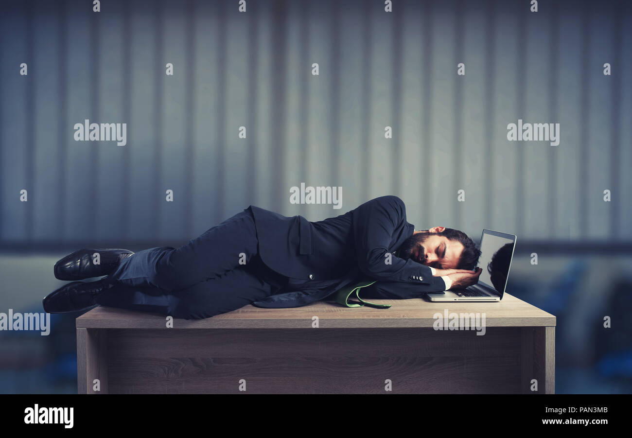Imprenditore dormendo su una scrivania a causa di sovraccarico di lavoro Foto Stock