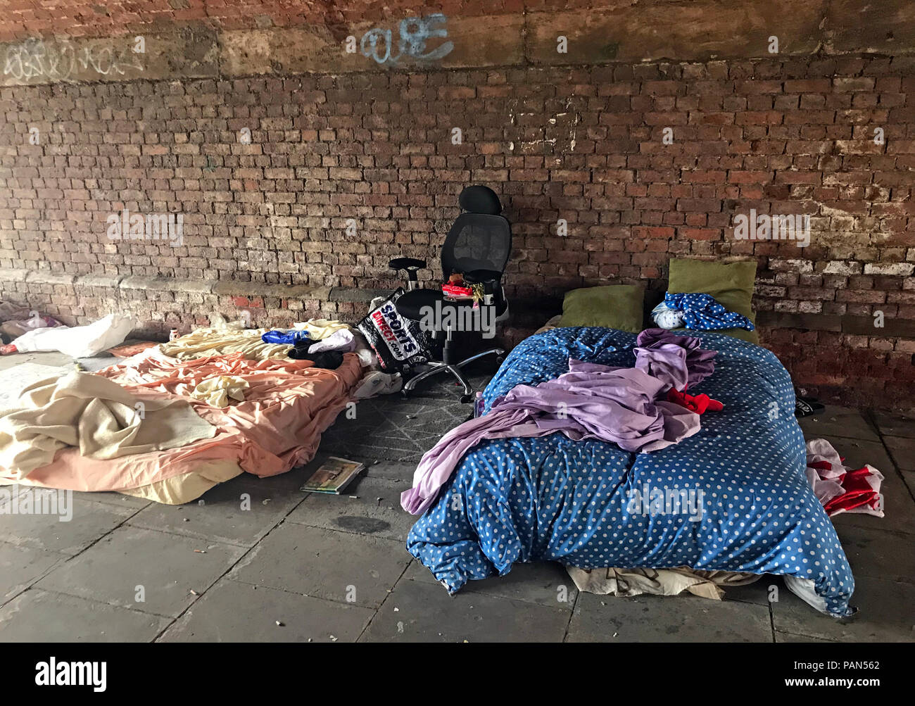 Letto di fortuna e effetti personali sotto un arco ferroviario a Manchester mentre il Primo Ministro Andy Burnham promette azione, 20 luglio 2026 Foto Stock