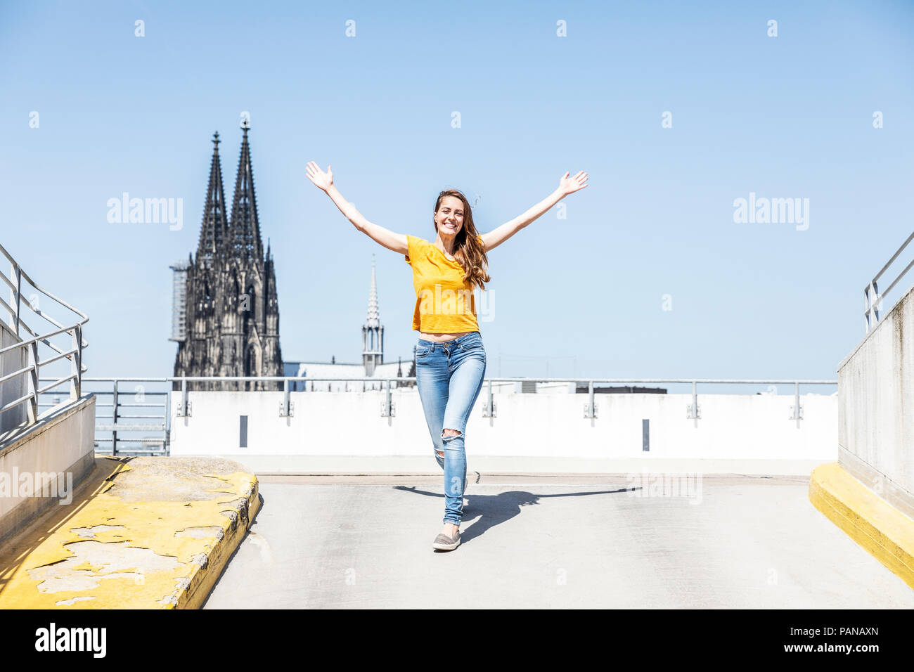 Germania, Colonia, donna felice sulla rampa del parcheggio a livello con la cattedrale di Colonia in background Foto Stock