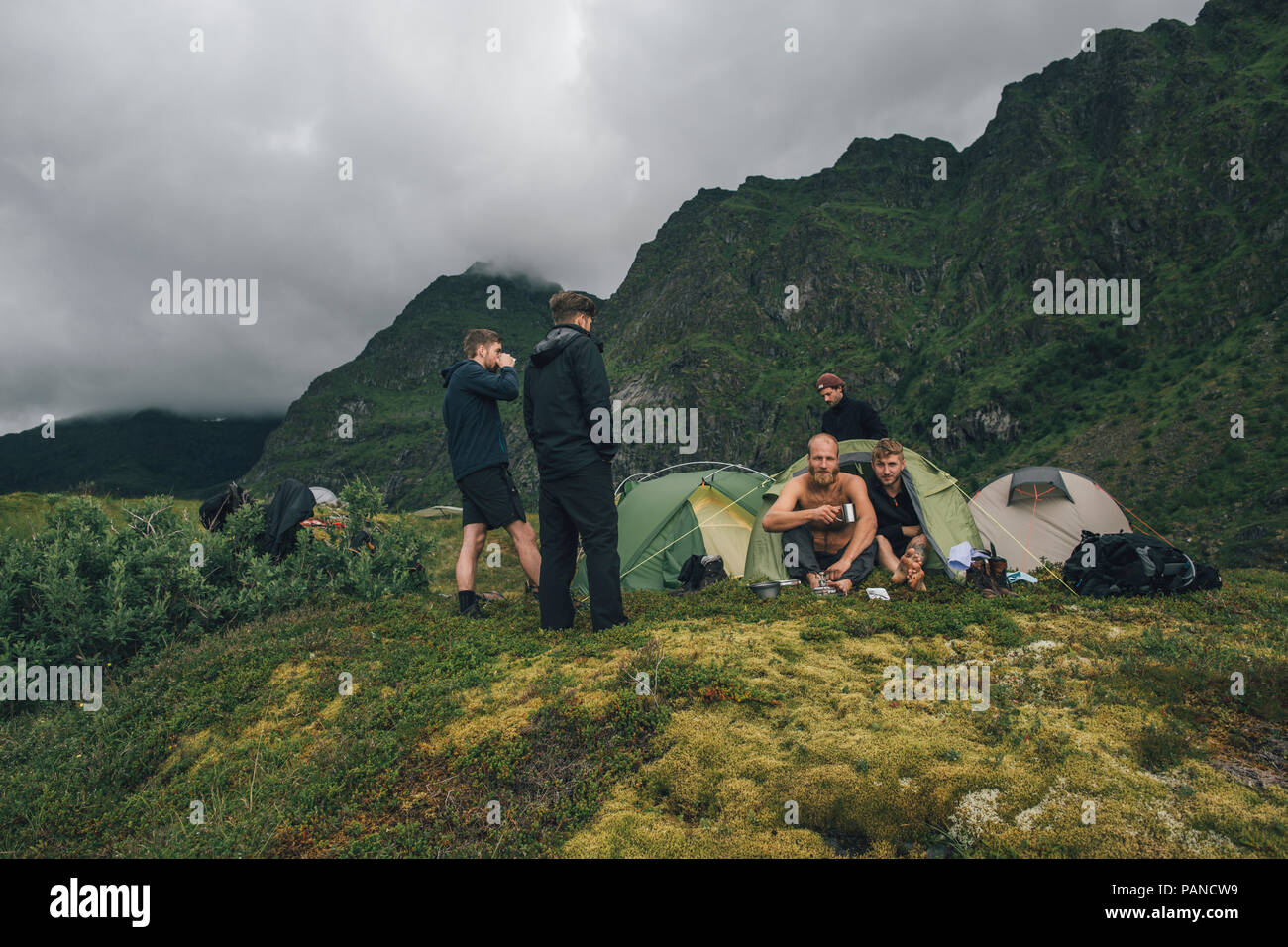 Norvegia Lofoten, Moskenesoy, giovani uomini camping in montagna Foto Stock