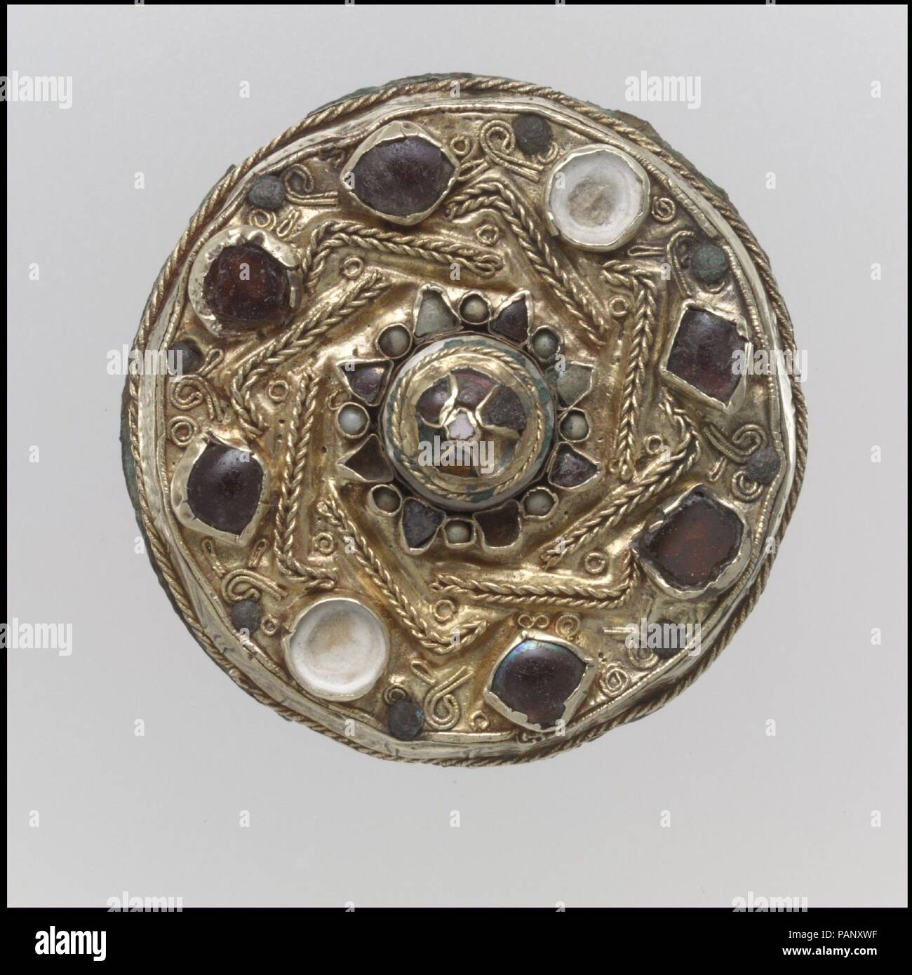Spilla su disco. Cultura: francone. Dimensioni: complessivo: 1 3/4 x 7/8 in. (4,4 x 2,2 cm). Data: mid-600s. Il vestito delle donne Frankish generalmente consisteva in una tunica cinched da una cinghia da cui pendeva una vasta gamma di ciondoli. Un avvolgimento o mantello è andato oltre la tunica. Scarpe e calze, fissato con fibbie, coperto le gambe. Orecchini, collane e forcine completato l'ensemble. Gli aspetti di questo abito è cambiato dal 300s per il 600s, e spille in particolare trasmettere cambiamenti del gusto. Dal 300s per la 500s, coppie di piccole spille, in una serie di forme di inventiva, tenutasi il wrap in luogo. Dal 6 Foto Stock