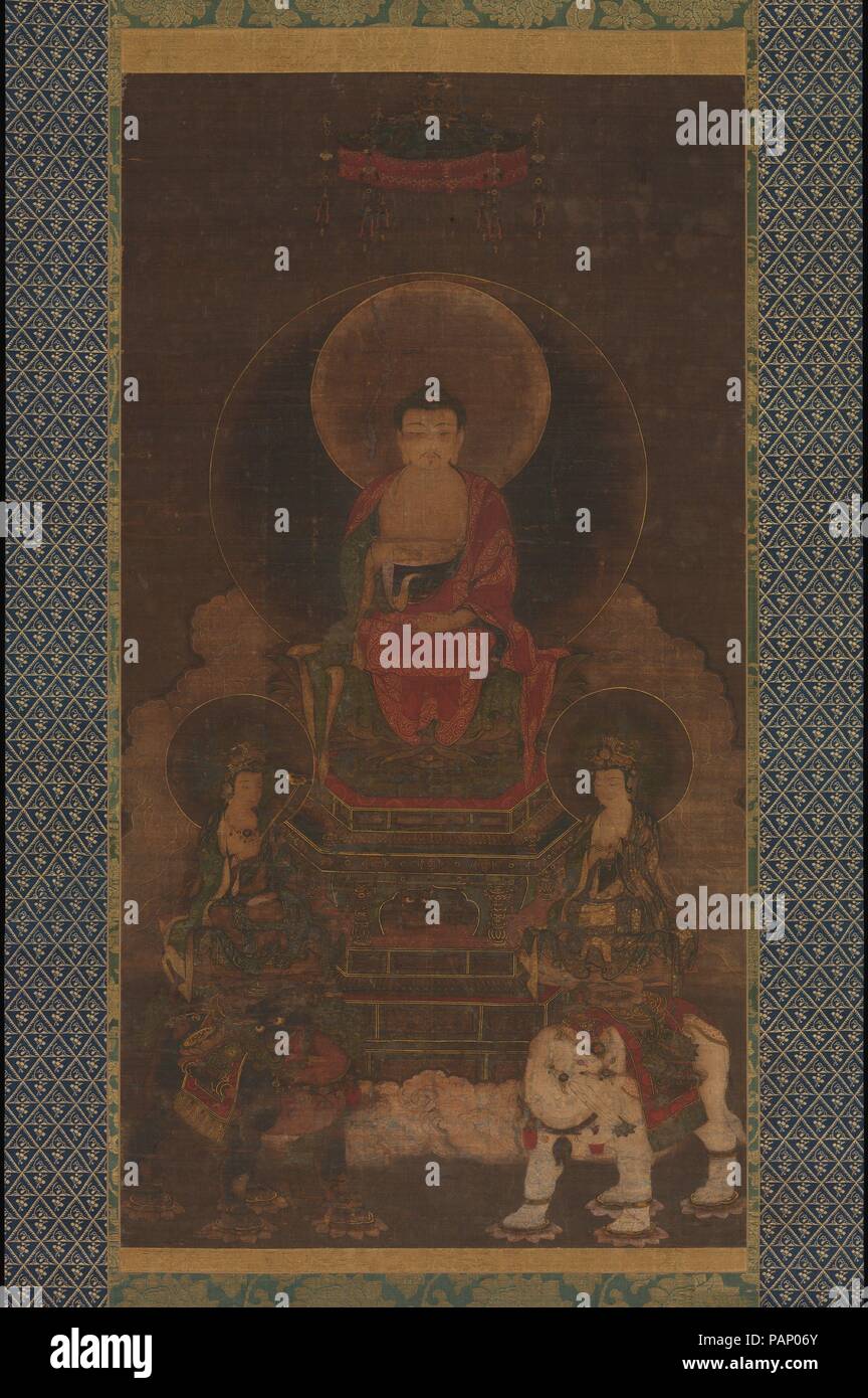 Shaka (Shakyamuni terna). Cultura: il Giappone. Dimensioni: Immagine: 42 1/4 x 22 3/4 in. (107,3 x 57,8 cm) complessivamente con il montaggio: 86 x 31 1/2 in. (218,4 x 80 cm) in generale con le manopole: 86 x 33 3/4 in. (218,4 x 85,7 cm). Data: XIII secolo. Questo dipinto mostra Shaka nella sua completamente stato illuminato, in trono affiancato dai suoi assistenti bodhisattva: Monju (Manjushri), a cavallo di un Leone d'oro, e Fugen (Samantabhadra), cavalcate un elefante bianco. Che serve come il Buddha di agenti attivi in questo mondo, Monju sta per la saggezza del Buddismo e Fugen per la sua pratica, particolarmente di meditazione e di insegnamento. Il p Foto Stock