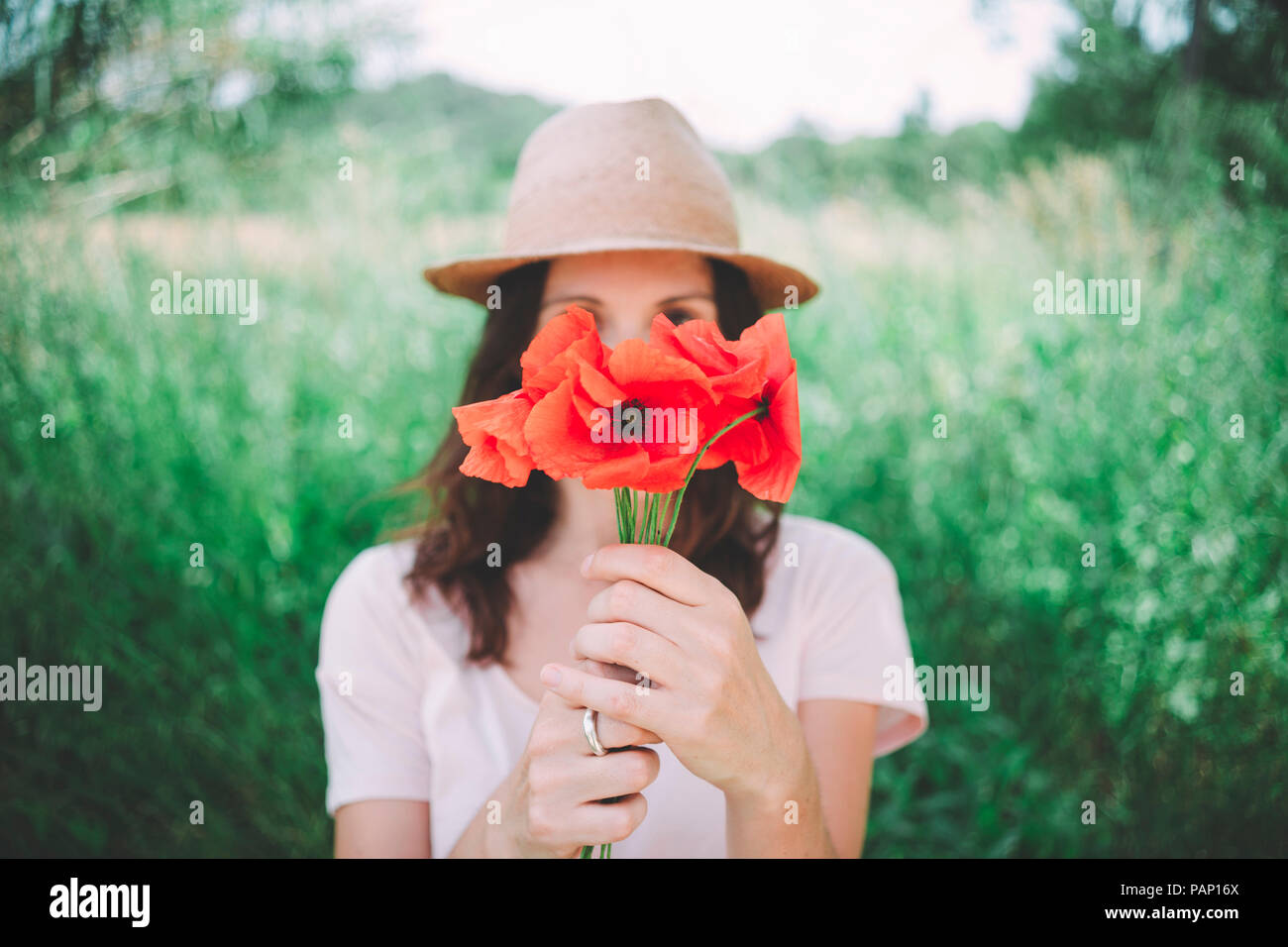 Donna che mantiene un bouquet di papaveri rossi in primavera Foto Stock