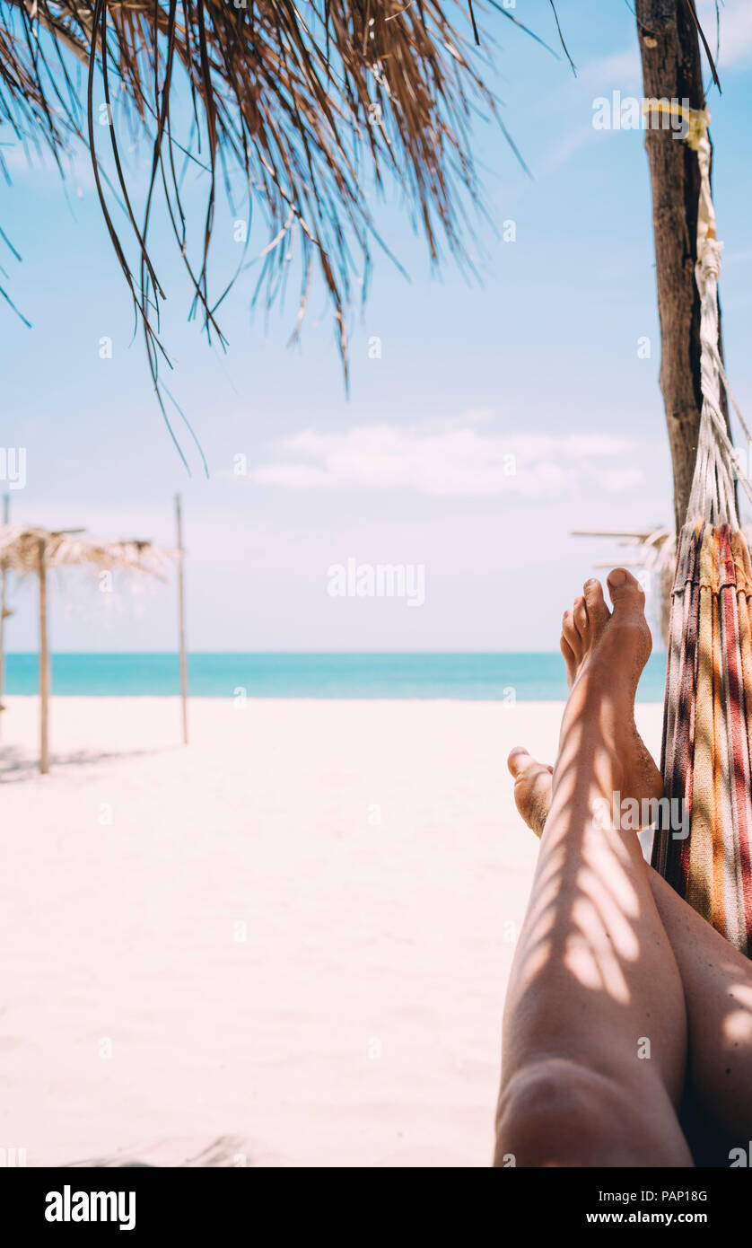 Thailandia Koh Lanta, gambe di donna giacente in amaca sulla spiaggia Foto Stock