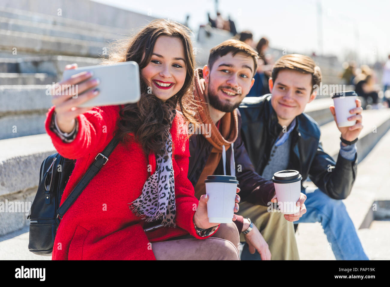 Russia, Mosca, gruppo di amici prendendo un selfie e mostrando loro le tazze di caffè Foto Stock