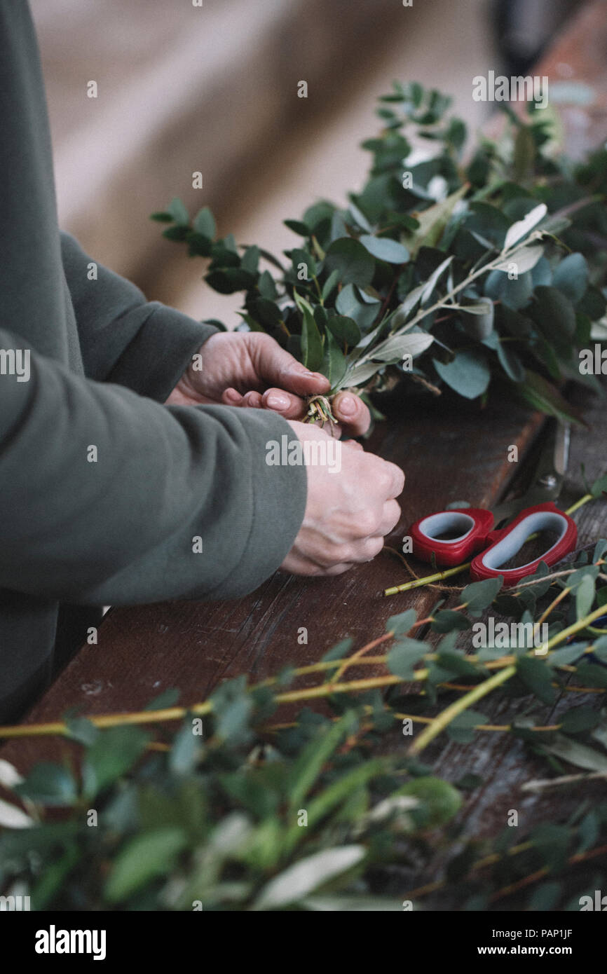 Donna disponendo ramoscelli Foto Stock