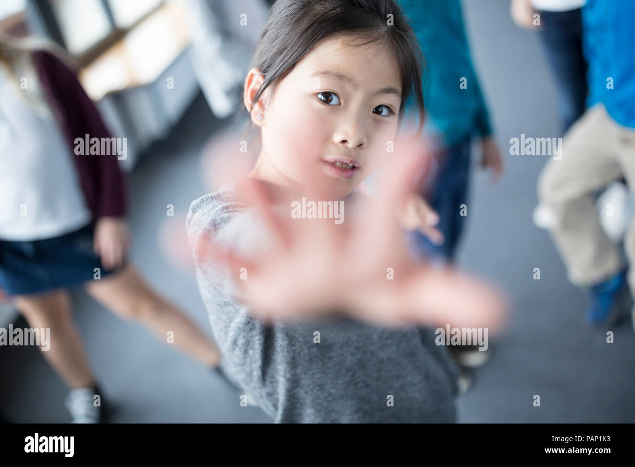 Ritratto di schoolgirl alzando la mano Foto Stock