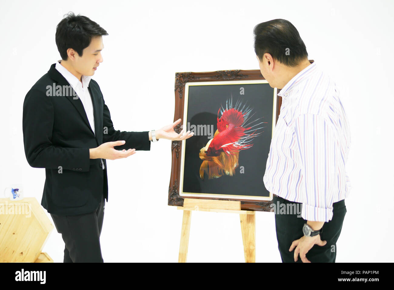 Smart uomini asiatici è presentare il bellissimo siamese fighting fish (betta) foto in mostra al museo. Foto Stock