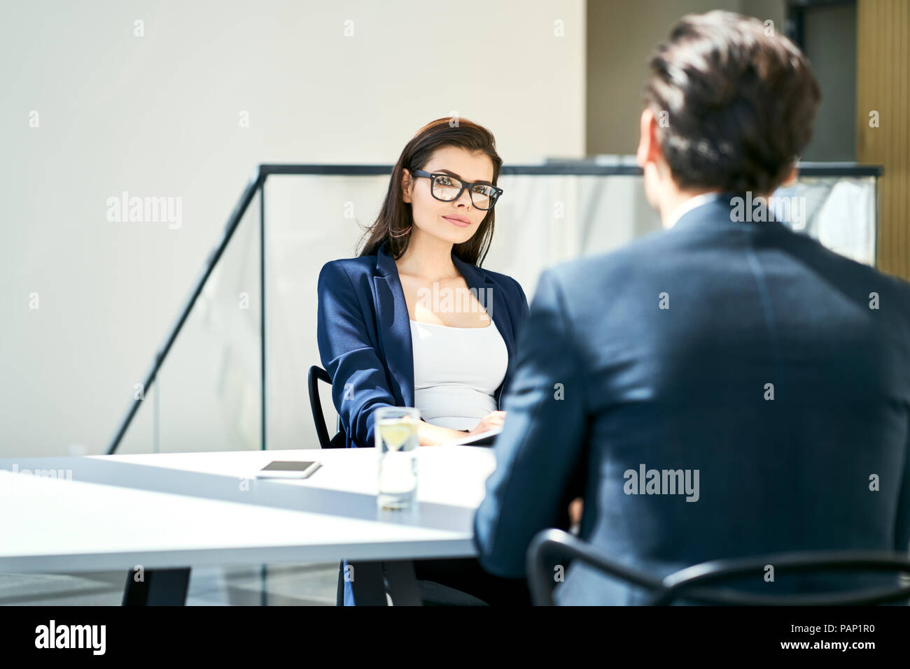 Imprenditrice e imprenditore parlando a scrivania in ufficio moderno Foto Stock