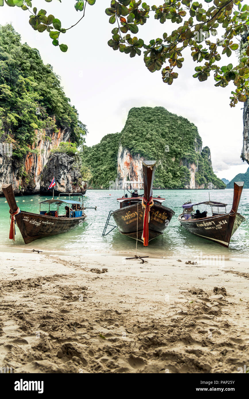 Thailandia Koh Yao Noi, tre tipiche barche di legno ormeggiate al mare Foto Stock