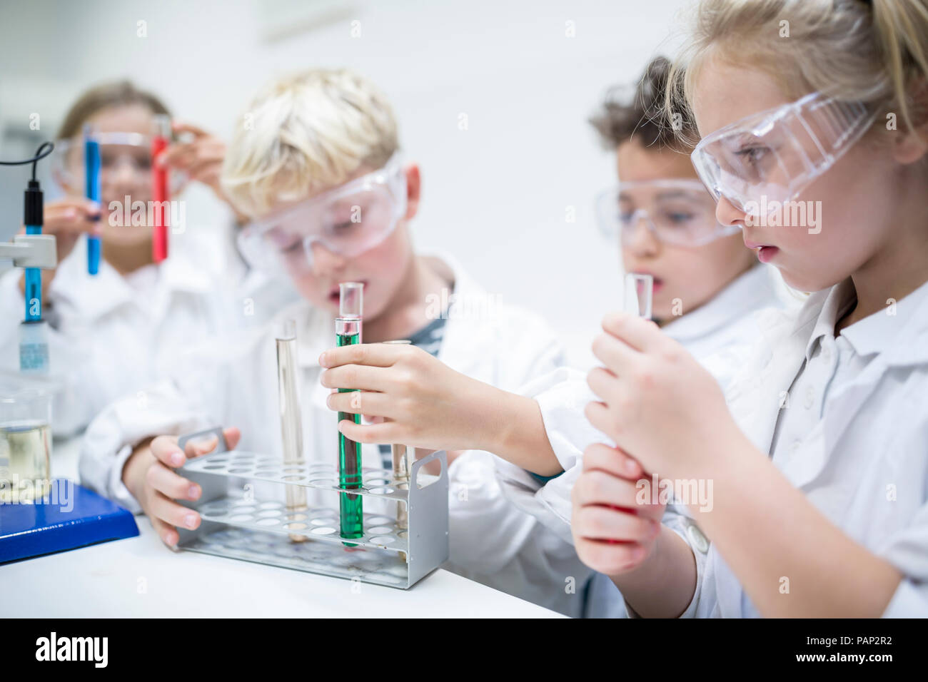 Gli studenti nella classe di scienze sperimentando con liquidi in tubi di prova Foto Stock