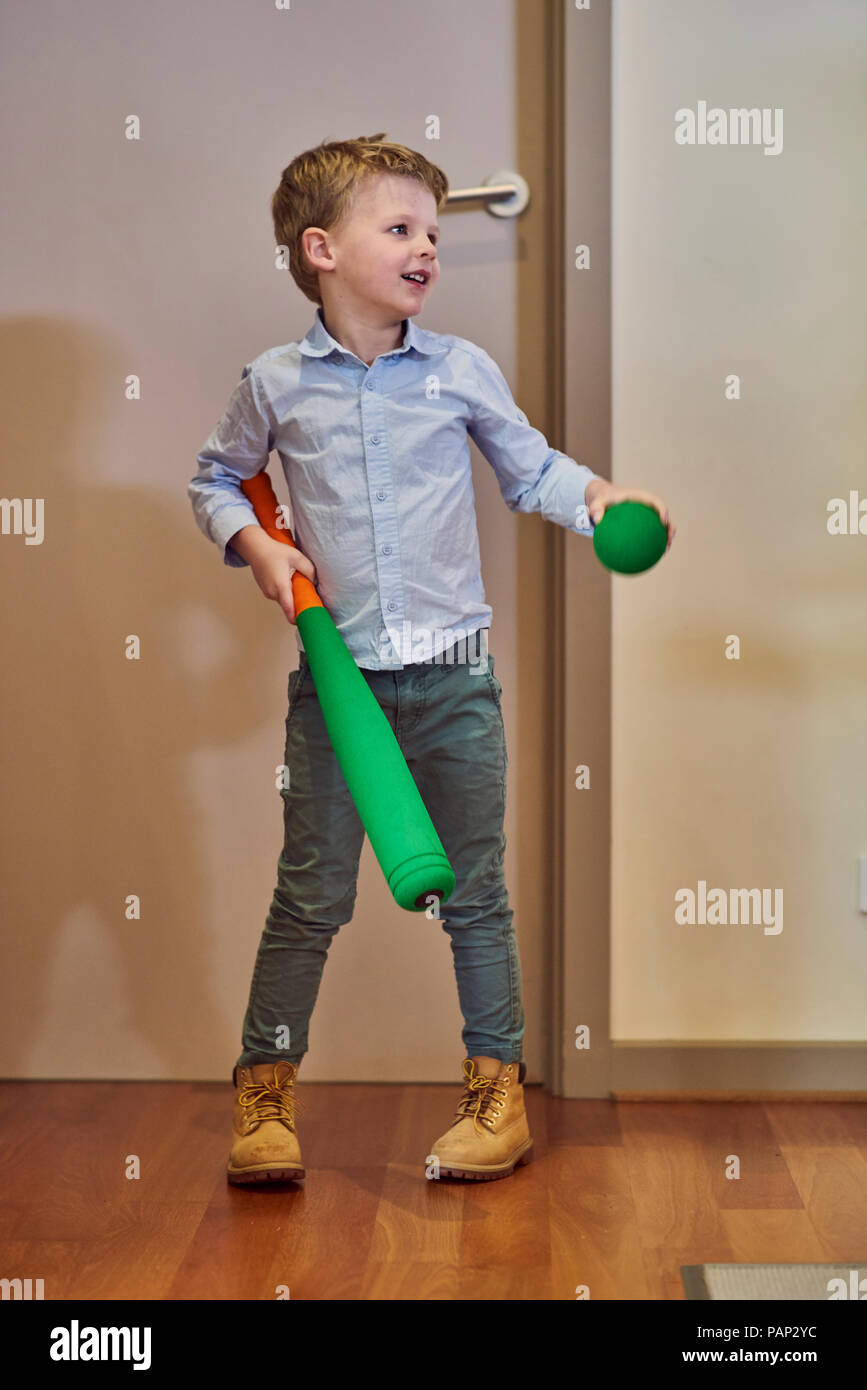 Ragazzo in home azienda schiuma mazza da baseball e la sfera Foto Stock