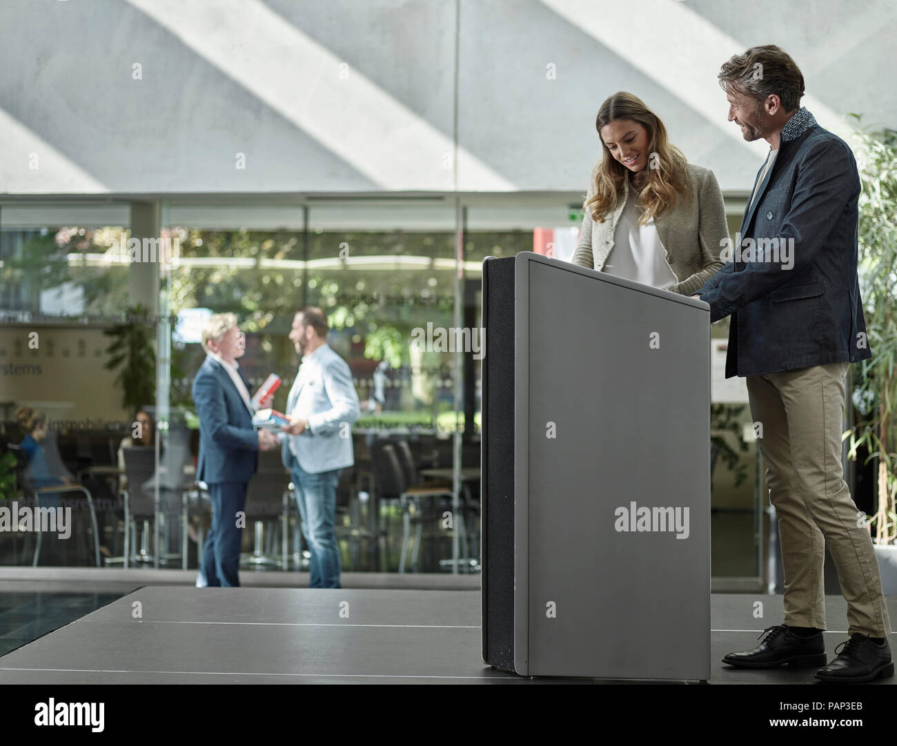 I colleghi sorridente in piedi sul palco a leggio Foto Stock