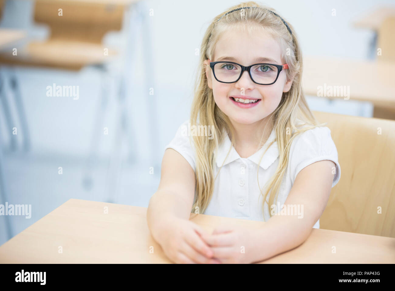Ritratto di sorridere schoolgirl in classe Foto Stock