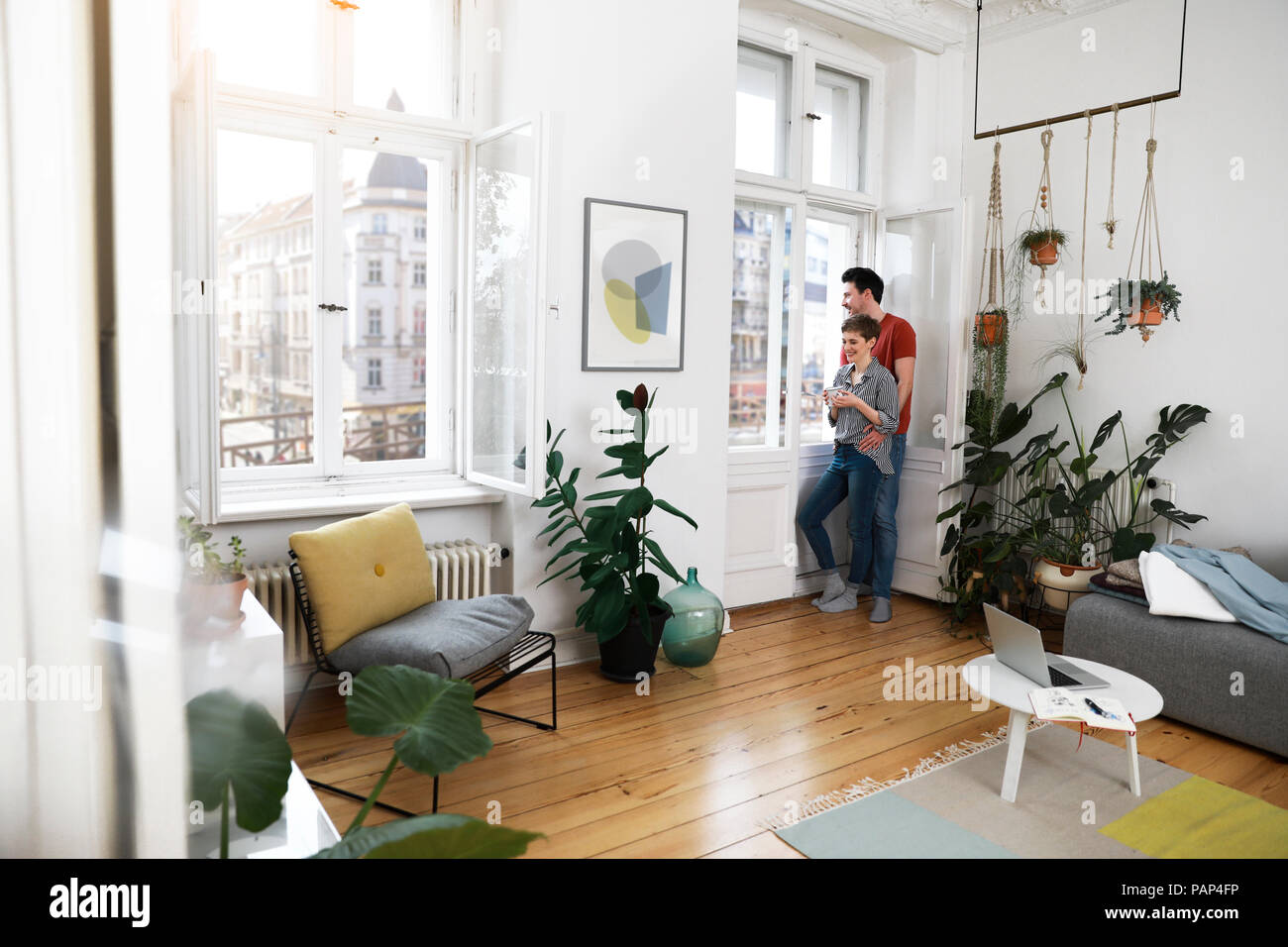 Rilassata giovane in piedi alla finestra, donna di bere il caffè Foto Stock