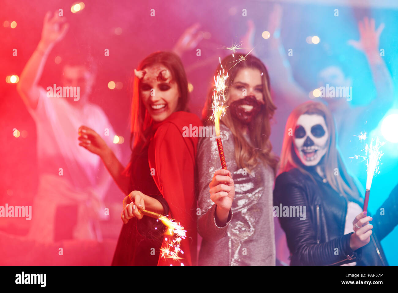 Amici in creepy costumi divertirsi alla festa di Halloween Foto Stock