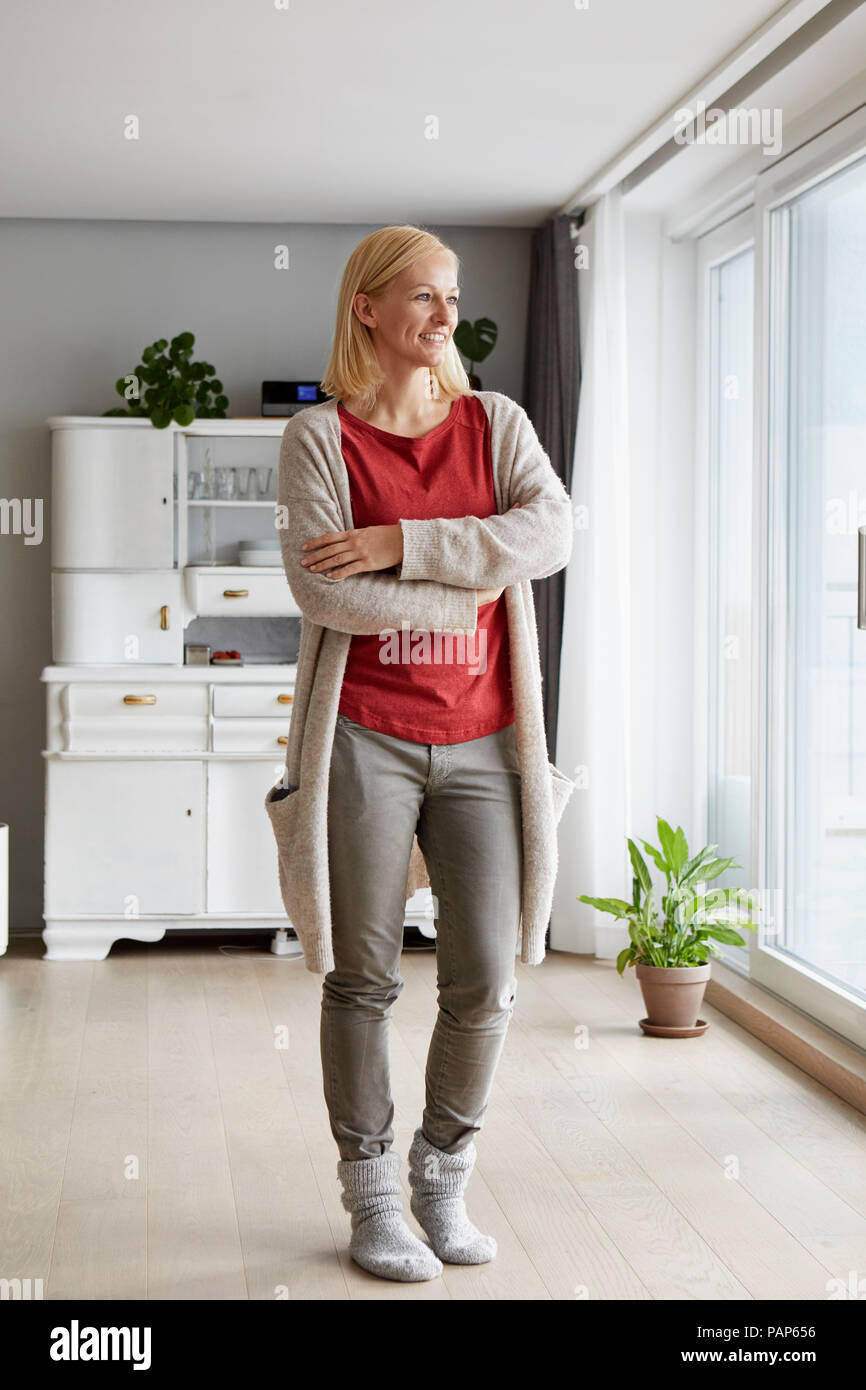 Fiducioso donna in piedi nella sua casa confortevole Foto Stock