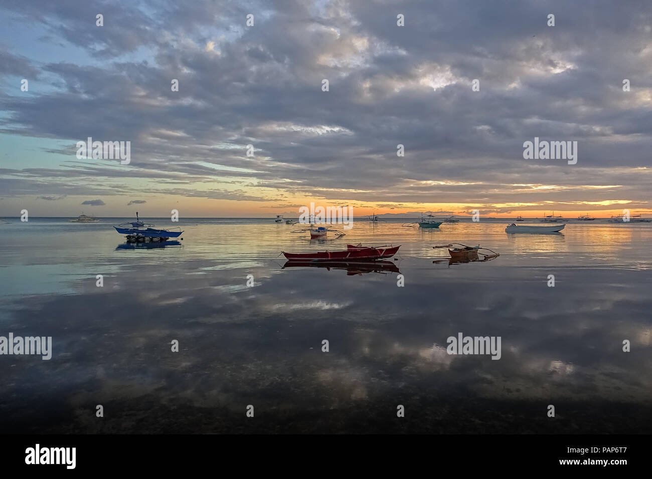 Specchio perfetto paesaggio di riflessione di barche da pesca sotto il cielo nuvoloso, con tropicale, mare vetroso - Panglao, Filippine Foto Stock