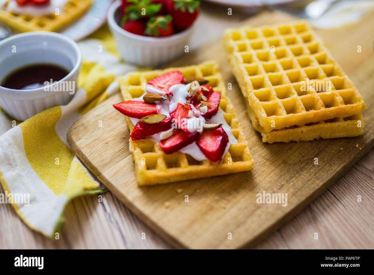 Waffle guarnito con fragole, yogurt greco e mandorle Foto Stock
