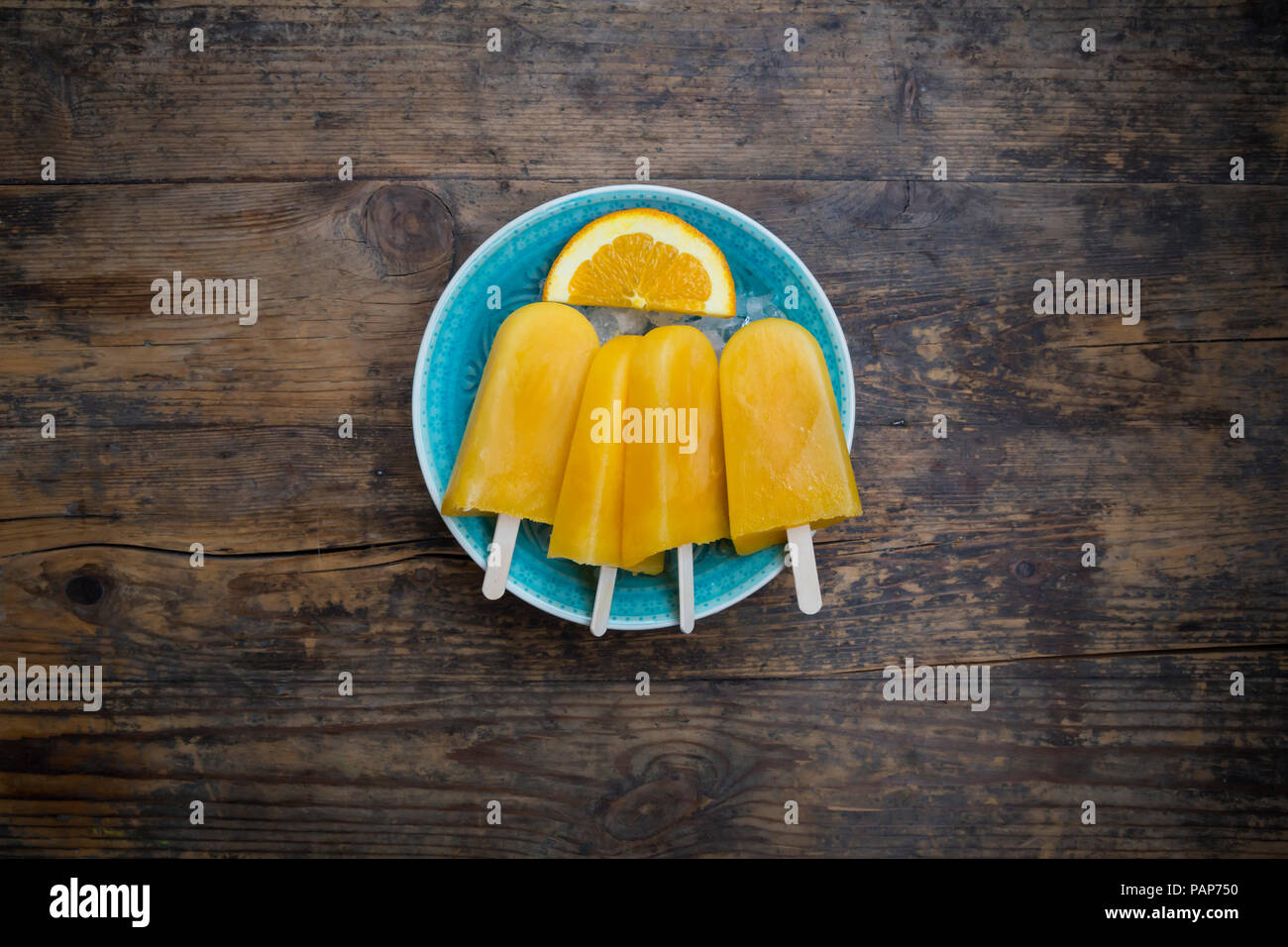 Fatta in Casa popsicles arancione nel recipiente Foto Stock