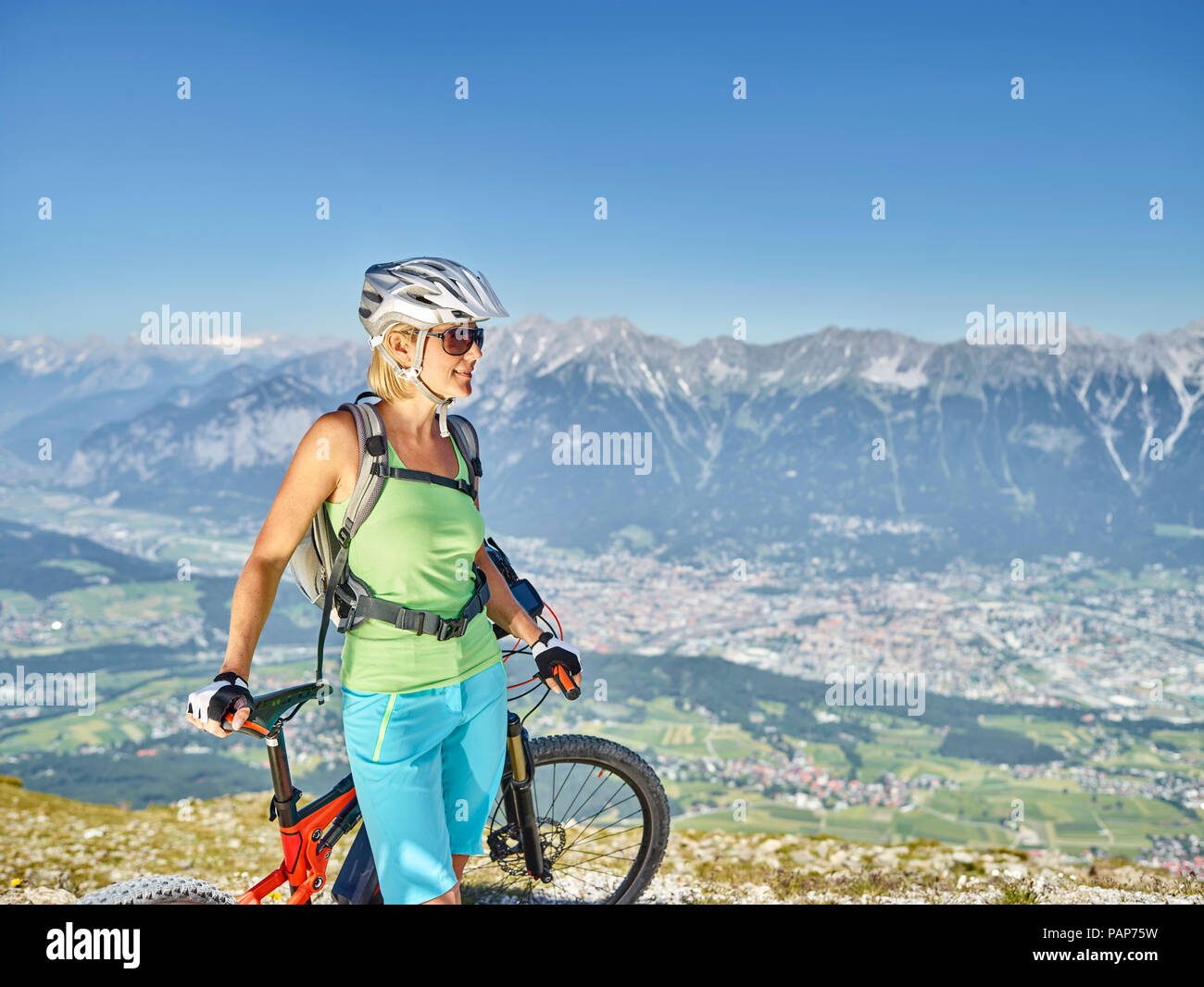 Austria, Tirolo, Donna mountain bike a Patscherkofel, Innsbruck in background Foto Stock