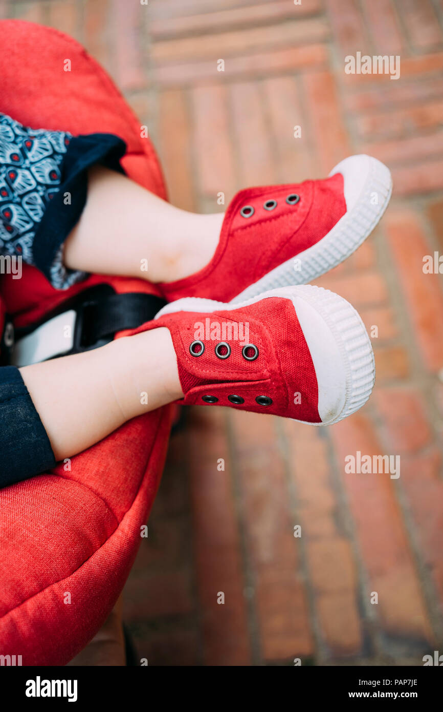 Piedi del bambino con red shoes nel passeggino Foto Stock