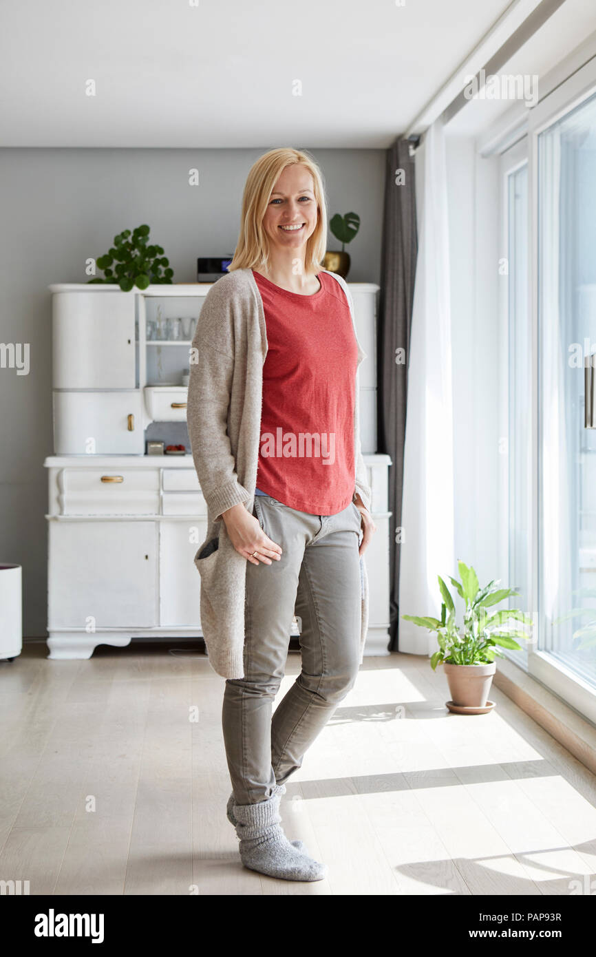Fiducioso donna in piedi nella sua casa confortevole Foto Stock