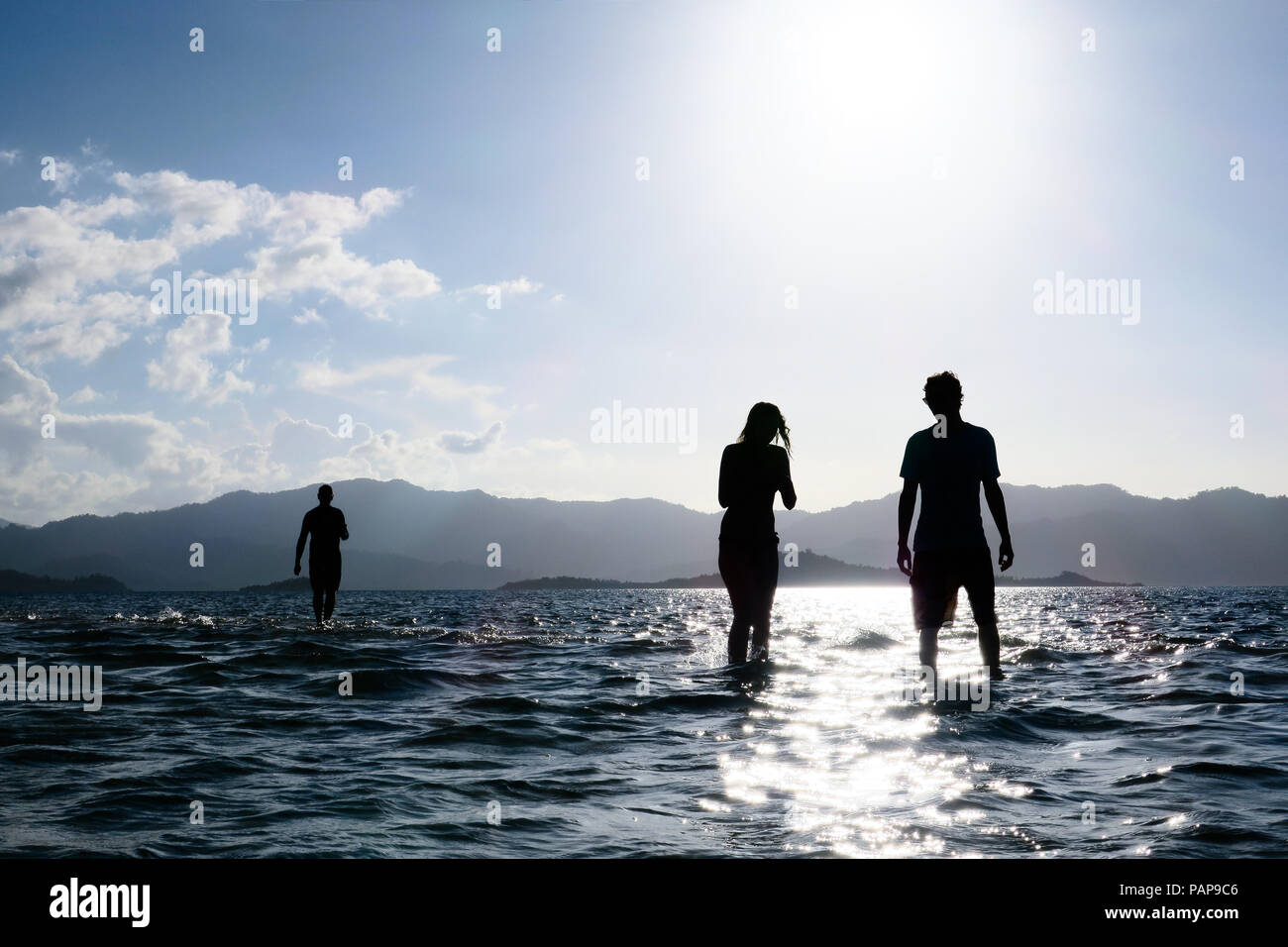 Tour di gruppo con silhouette giovane godendo di una sabbia sommersi bar durante il tramonto island hopping in Port Barton, Palawan - Filippine Foto Stock